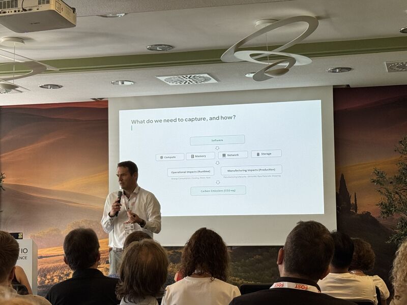 Prof. Dr. Andreas Brunnert bei der Keynote auf der Green IO Munich 2026, im Hintergrund die Folie „What do we need to capture, and how?“
